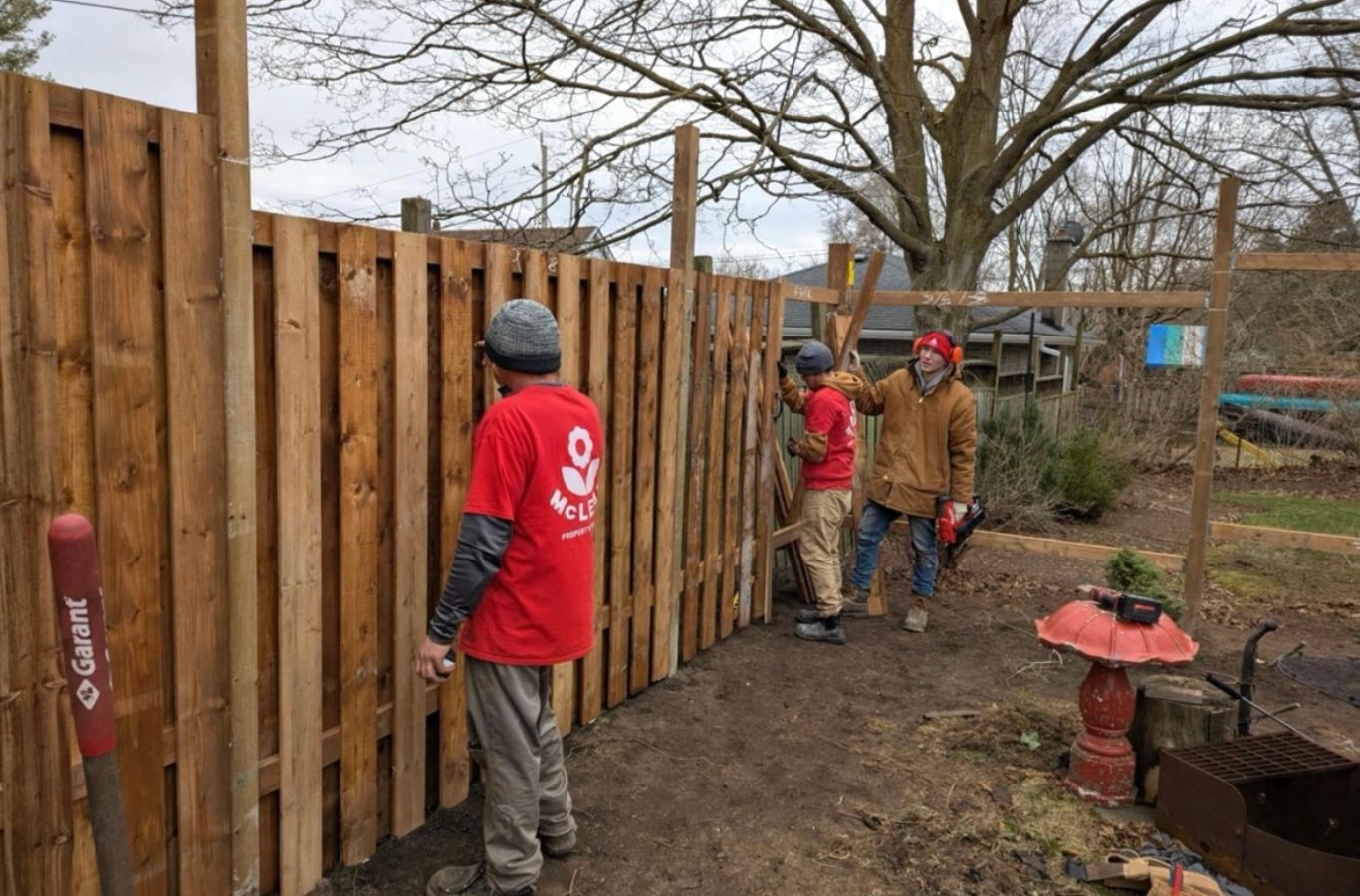 Fence professional checking level lines and secure post placement on residential property