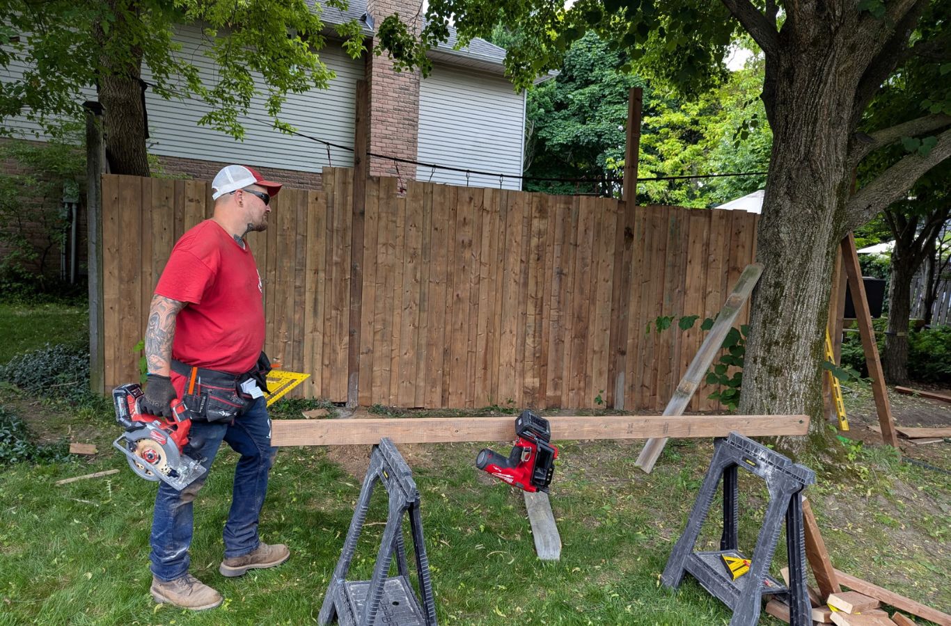 Experienced fence professional checking level and alignment during residential installation
